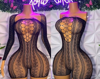 May include: Black lace bodysuit with long sleeves and a strapless version. Both feature a corset-style bodice with a lace-up design and intricate patterns. The sleeves are embellished with sparkling details.
