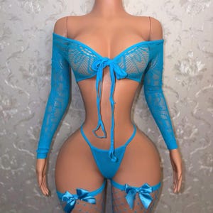 May include: A bright blue two-piece lingerie set featuring a long-sleeve off-the-shoulder crop top with a front tie closure and matching high-cut thong bottoms. The set includes two thigh-high fishnet stockings adorned with blue satin bows.
