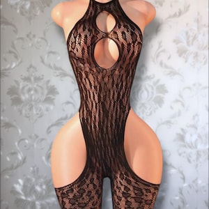 May include: A black lace bodysuit featuring a halter neckline with two circular cutouts on the chest. The garment is crafted from a sheer, intricate floral pattern mesh fabric that extends down to the thighs with high-cut leg openings.