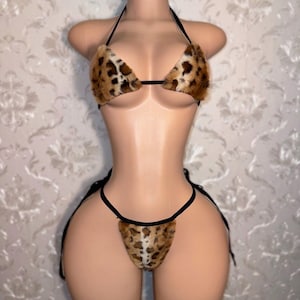 May include: A black and brown leopard print lingerie set with a triangle top and a thong bottom.