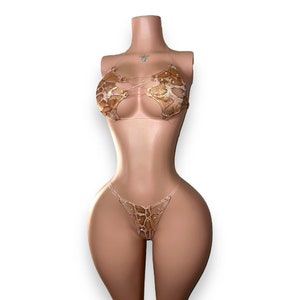 May include: A two-piece swimsuit with a snake print top and bottom. The top has a criss-cross design and the bottom is a simple bikini cut.