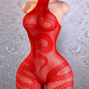 May include: A vibrant red fishnet bodysuit featuring a high neckline and a repeating snake pattern integrated into the mesh weave. The garment is displayed on a mannequin, showcasing the intricate texture and the bold, serpentine design throughout.