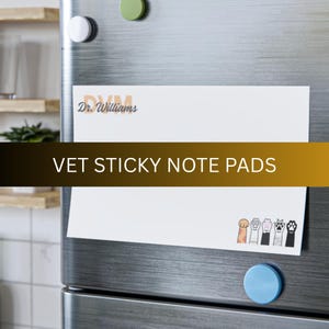 May include: White sticky note pad with the text "VET STICKY NOTE PADS" in brown text. The pad is on a stainless steel refrigerator with a blue magnet and a green magnet. The pad has a small illustration of paw prints at the bottom.