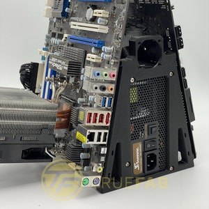 May include: A black computer case with a motherboard and a power supply unit installed. The case is made of metal and has a mesh front panel. The motherboard is a blue and black circuit board with a variety of components, including a CPU cooler, RAM slots, and expansion slots. The power supply unit is a black box with a power cord and a switch.