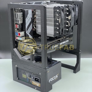 May include: A black open-frame computer case with internal components. It includes a power supply, a graphics card labelled "GeForce RTX", and a large CPU cooler. The text "FRC LAB" is visible on the side.