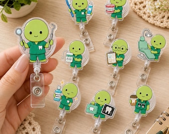 Op de afbeelding: Een collectie intrekbare badgehouders met stripfiguren in groene tandartsuniformen. Elk figuur houdt verschillende tandheelkundige voorwerpen vast, waaronder een tandenborstel, tandpasta, een kunstgebit, flosdraad, mondwater, een klembord en een röntgenfoto.