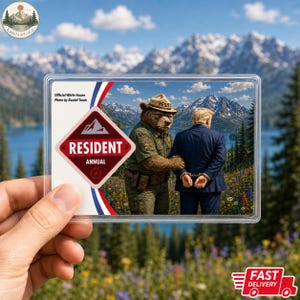 May include: A rectangular trading card featuring a park ranger bear in a tan uniform and hat placing handcuffs on a person in a dark blue suit. The card displays the text Official White House Photo by Daniel Torok and RESIDENT ANNUAL.