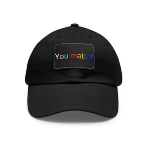 May include: A black baseball cap with a rainbow coloured patch that says "You matter".