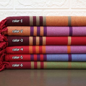 Peut inclure: Six échantillons de tissu rayés empilés les uns sur les autres. Les échantillons sont dans l'ordre suivant de haut en bas : orange, violet, rouge, violet, bleu, vert. Chaque échantillon porte l'inscription "color-1", "color-2", "color-3", "color-4", "color-5" et "color-6" imprimée dessus.