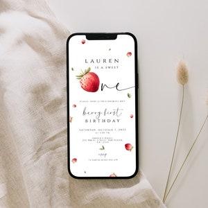 Puede incluir: Un smartphone muestra una invitación de primer cumpleaños con temática de fresas. La invitación dice "Lauren is a sweet one" con una ilustración de fresa en acuarela. La invitación incluye la fecha, la hora y el lugar.