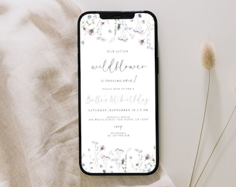 May include: A digital invitation with a floral design featuring a white background and purple and blue flowers. The text reads "Our Little Wildflower is turning one!" and includes a date and time for a birthday party.