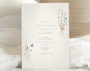 May include: A white card with a floral design and the text "Our little Wildflower is turning one. Join us to celebrate Lauren's First Birthday. Saturday, October 1, 2027 at 2 pm. [Address] RSVP to [Phone Number]"