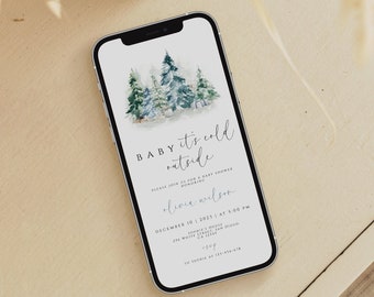 May include: A digital invitation on a smartphone screen for a baby shower. The invitation features a watercolor illustration of a winter forest with the text "Baby it's cold outside". The invitation is for Olivia Wilson and is scheduled for December 10, 2023 at 3:00 PM.