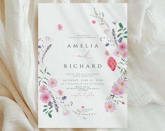 May include: A white wedding invitation with floral watercolor accents. The invitation features the names "Amelia" and "Richard" in elegant script, along with event details. The design includes pink and purple flowers and green foliage.
