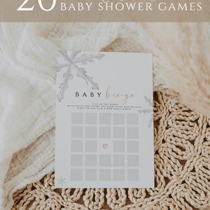 Pode incluir: Um cart&atilde;o de bingo de ch&aacute; de beb&ecirc; imprim&iacute;vel com um design de floco de neve. O cart&atilde;o tem um t&iacute;tulo que diz "Baby Bingo" e instru&ccedil;&otilde;es para preencher as caixas com os presentes que a futura mam&atilde;e pode receber. A primeira pessoa a obter cinco em uma linha grita "Bingo!"