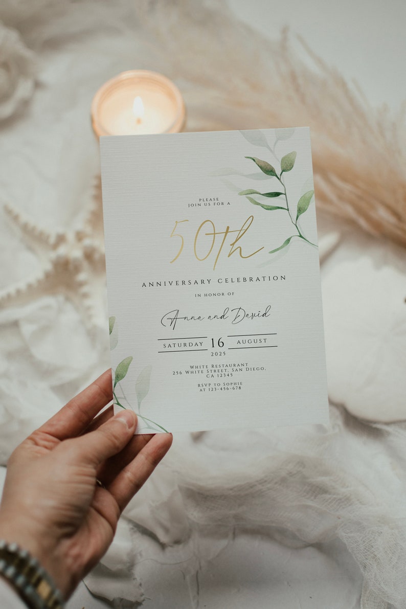 Pu&ograve; includere: Un invito bianco con lettere dorate che annunciano una celebrazione del 50&deg; anniversario per Anna e David. L'evento si terr&agrave; sabato 16 agosto 2025 al ristorante White a San Diego, California. RSVP a Sophie al 123-456-678.