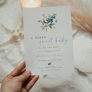 Może przedstawiać: Zaproszenie na baby shower z akwarelową ilustracją jag&oacute;d i liści. Zaproszenie zawiera napis "A Berry Sweet Baby is on the Way!" oraz imię "Christina Williams", datę "September 16, 2023" i godzinę "5 PM".