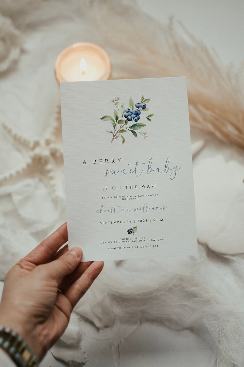 Może przedstawiać: Zaproszenie na baby shower z akwarelową ilustracją jag&oacute;d i liści. Zaproszenie zawiera napis "A Berry Sweet Baby is on the Way!" oraz imię "Christina Williams", datę "September 16, 2023" i godzinę "5 PM".