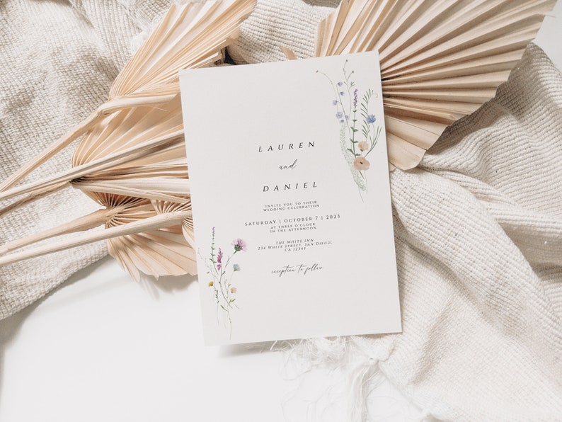 May include: A wedding invitation with a floral design featuring a bouquet of purple, pink, and white wildflowers. The invitation reads "Lauren and Daniel" and includes the date "Saturday, October 7, 2023" and the location "The White Inn, 274 Whitelaw Drive, CA 91745".
