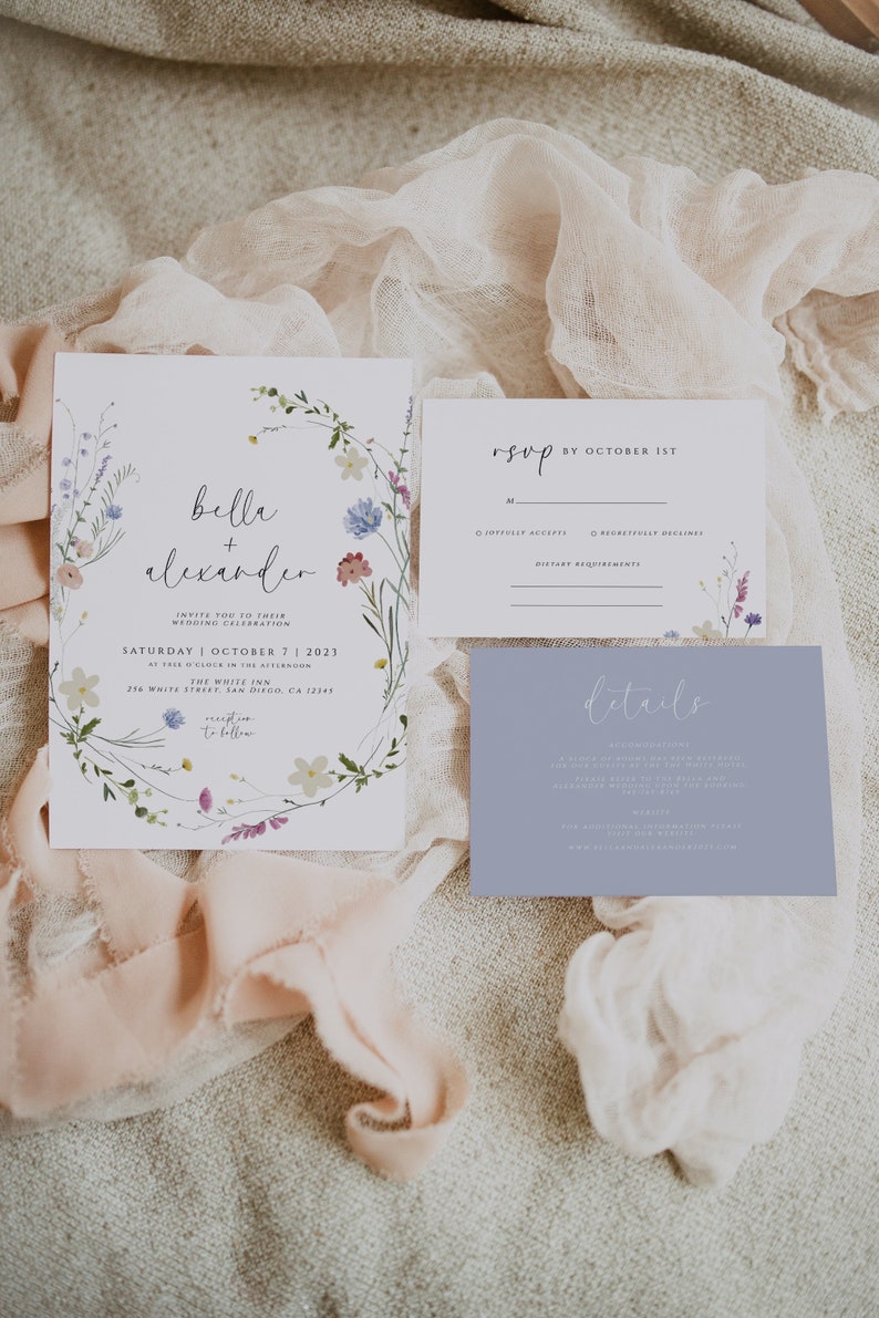 May include: Wedding invitation suite with a floral wreath design. The invitation card features the names "Bella + Alexander" and details about the wedding ceremony and reception. The RSVP card includes options for guests to accept or decline the invitation and a space for dietary requirements. The details card provides information about the wedding, including the location, website, and accommodations.
