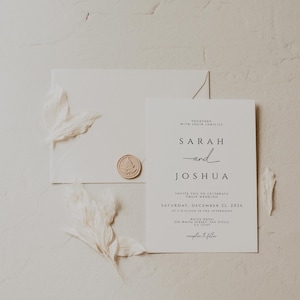 K&ouml;nnte beinhalten: Elegante Hochzeitseinladung mit cremefarbener Einladungskarte, Umschlag und Wachssiegel. Die Einladung enth&auml;lt die Namen "Sarah und Joshua" und Hochzeitsdetails. Dekorative Federn sorgen f&uuml;r eine zarte Note.