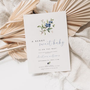 Może przedstawiać: Białe zaproszenie na baby shower z akwarelową ilustracją jag&oacute;d i zielonych liści. Tekst brzmi "A berry sweet baby is on the way!" i zawiera imię "christine williams" oraz datę "September 16, 2023, 3 PM".