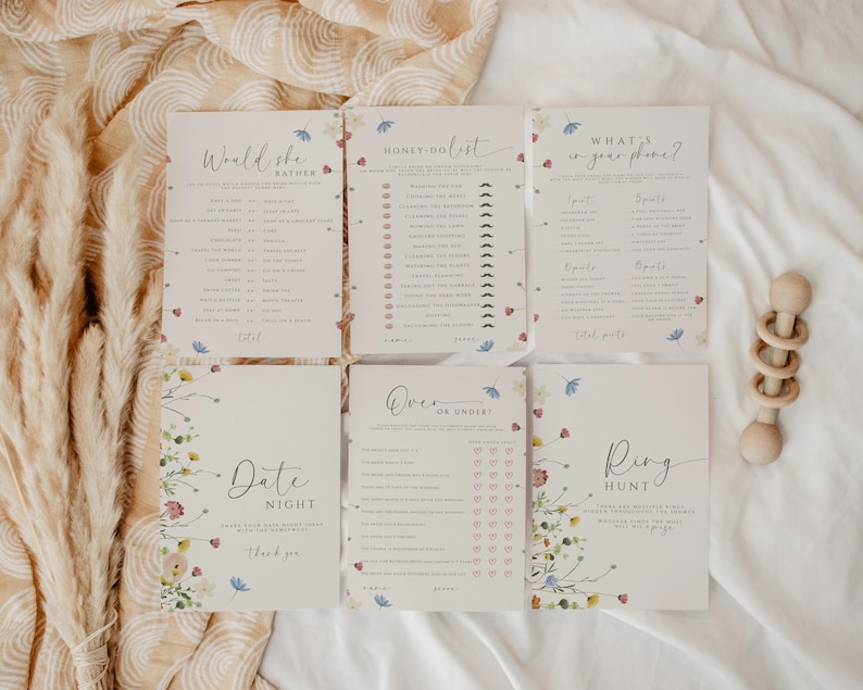 May include: Five printable baby shower game cards with floral designs. The games include "Would She Rather", "Honey Do List", "What's in Your Phone", "Over or Under", and "Ring Hunt".