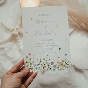 May include: A wedding invitation featuring a floral design. The invitation is for Olivia and Nicholas and is set for 26 August 2024 at 3 o'clock in the afternoon at The White Restaurant in San Diego, CA 12345. The invitation states "reception to follow".
