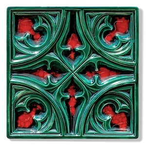 May include: Square ceramic tile with a glossy green and red design. The tile features a repeating pattern of stylized floral or foliate elements, with a dark green background and red accents. The design is symmetrical and ornate.