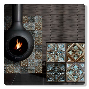 Può includere: Un camino in metallo nero con un fuoco che brucia all'interno, circondato da piastrelle con motivi blu e marroni. Le piastrelle sono disposte a griglia e hanno un aspetto usurato.