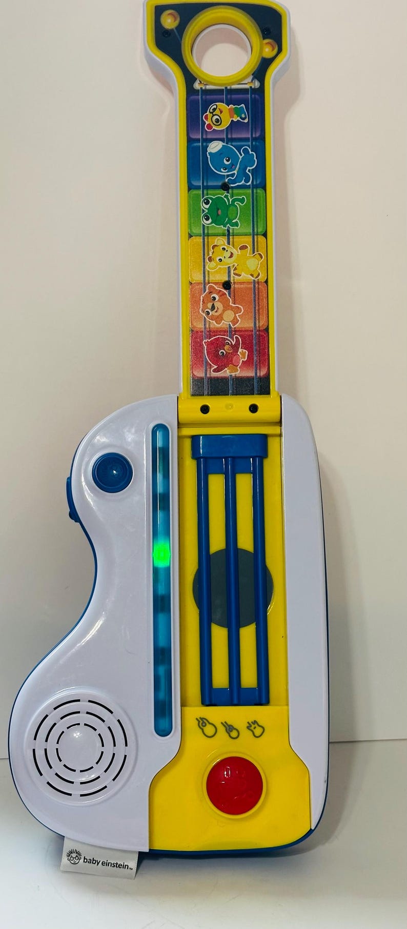 Pode incluir: Uma guitarra de brinquedo Baby Einstein colorida. &Eacute; principalmente branca e amarela, com detalhes azuis. Apresenta gr&aacute;ficos de animais e um bot&atilde;o vermelho. O logotipo da Baby Einstein &eacute; vis&iacute;vel.