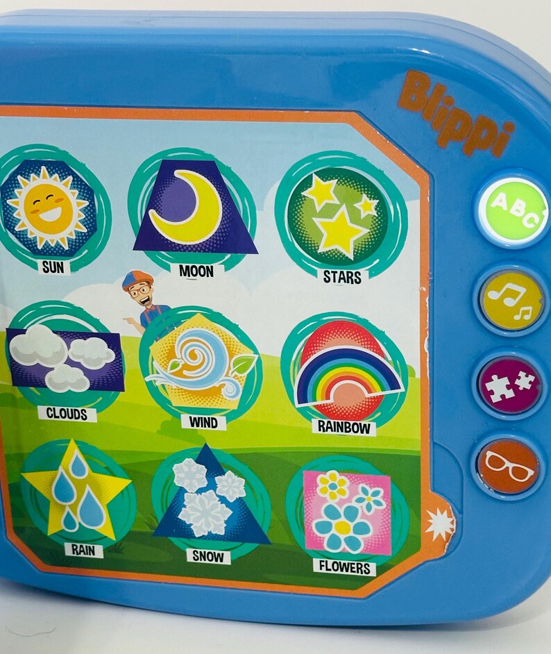 May include: A blue Blippi-themed educational toy with colorful illustrations of the sun, moon, stars, clouds, wind, rainbow, rain, snow, and flowers. The toy has buttons with ABC, music notes, puzzle pieces, and glasses icons.
