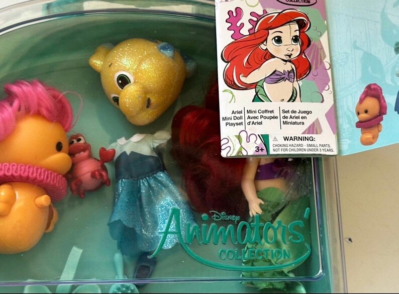 May include: Ariel Mini Doll Playset from the Disney Animators' Collection. The set includes a doll with red hair, a blue dress, and several character figures. The packaging features Ariel's image and the text "Ariel Mini Doll Playset".