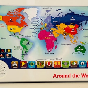 May include: Educational world map toy with a white frame. The map is color-coded by continent and features country names and oceans. Includes buttons for power, true/false, and other interactive features. The text "Around the World" is displayed at the bottom.