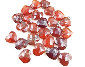 May include: A collection of 20 heart-shaped red gemstone cabochons. The gemstones are faceted and have a polished finish.