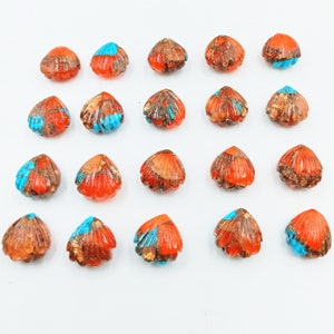 May include: Twenty orange and blue shell-shaped cabochons with gold flecks. The cabochons are approximately 1 inch in diameter.