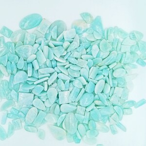 K&ouml;nnte beinhalten: Ein gro&szlig;er Haufen hellblauer und gr&uuml;ner Edelsteine in verschiedenen Formen und Gr&ouml;&szlig;en. Die Edelsteine sind glatt und poliert und haben ein durchscheinendes Aussehen.