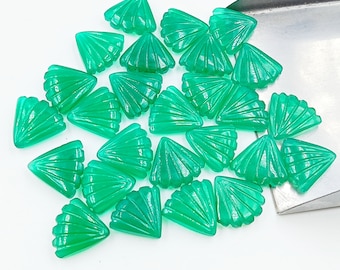 Puede incluir: Una colección de 20 cabujones de piedra preciosa verde con un diseño en forma de abanico. Los cabujones son de forma triangular y tienen una superficie lisa y pulida.