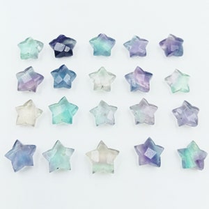 May include: Twenty-one star-shaped fluorite crystals in various shades of blue, green, and purple. The crystals are faceted and have a translucent appearance.