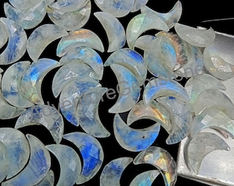 May include: A collection of iridescent moonstone crescent shapes. The stones are a translucent white with a rainbow sheen.