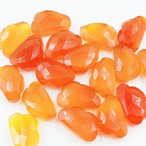 Puede incluir: Una colección de 15 cuentas de piedra de cornalina naranja y amarilla en forma de nube. Las cuentas son facetadas y tienen un acabado brillante.