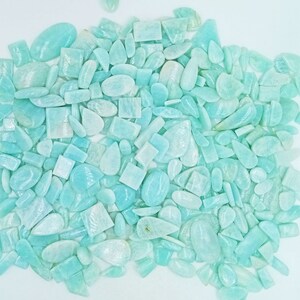 K&ouml;nnte beinhalten: Eine gro&szlig;e Sammlung von hellblauen und gr&uuml;nen Amazonit-Edelsteinen in verschiedenen Formen und Gr&ouml;&szlig;en, darunter ovale, tropfenf&ouml;rmige und quadratische.