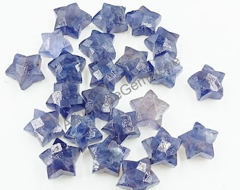 May include: A collection of 20 star-shaped blue sapphire gemstones. The sapphires are faceted and have a light blue color.