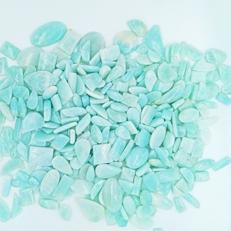 K&ouml;nnte beinhalten: Ein gro&szlig;er Haufen hellblauer und gr&uuml;ner Edelsteine in verschiedenen Formen und Gr&ouml;&szlig;en. Die Edelsteine sind glatt und poliert und haben ein durchscheinendes Aussehen.