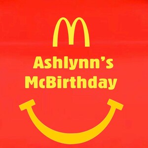 May include: Red background with the McDonald's golden arches logo and a yellow smiling face. The text "Ashlynn's McBirthday" is written in yellow, celebrating a birthday with a McDonald's theme.