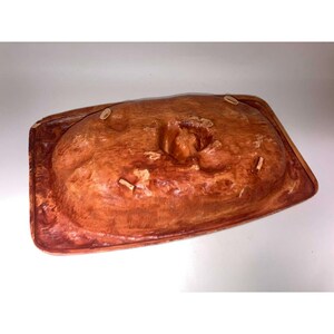 May include: A white ceramic mug with a black handle and the text "But First, Coffee" in a bold, black font. The mug is filled with a dark liquid, likely coffee, and sits on a light-colored surface.