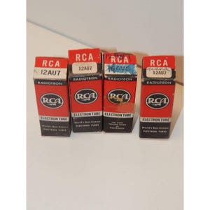 May include: Four vintage RCA 12AU7 Radiotron electron tube boxes. The boxes are red and black with white text, featuring the RCA logo and the words "Electron Tube". Some boxes have handwritten notes.