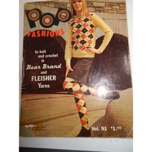 Puede incluir: Portada de revista vintage "Pop Fashions" con una mujer con un suéter amarillo y leggings de rombos. El suéter tiene un patrón de diamantes negros, rojos y crema. La portada de la revista también tiene el texto "to knit and crochet in Bear Brand and Fleisher Yarns."