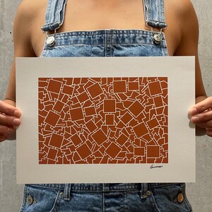 May include: A white print on brown paper with a geometric pattern of overlapping squares. The print is signed "Gunnars" in the bottom right corner.