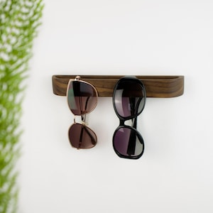Self adhesive glasses hook crafted from solid walnut wood, modern wall mounted reading glasses holder, practical wooden organizer for keeping eyewear in one place at home or office